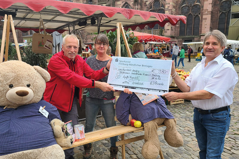 Scheckübergabe auf dem Münstermarkt - Apfelküchle-Verteilaktion von Conny und Walter Schwaab auf dem Münstermarkt Freiburg