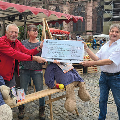 Scheckübergabe der Spenden - Apfelküchle-Verteilaktion von Conny und Walter Schwaab auf dem Münstermarkt Freiburg